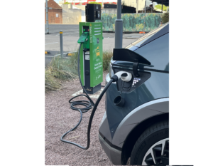 Photo of electric vehicle plugged into a charging station.